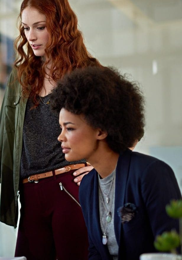 Cropped shot of colleagues working together on a laptop in a modern office.